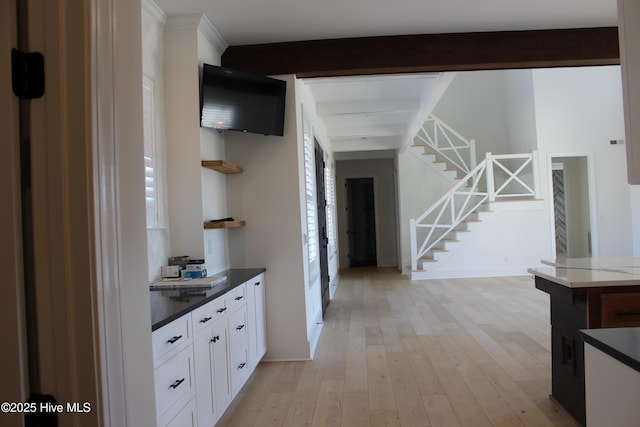 corridor with beam ceiling and light hardwood / wood-style flooring