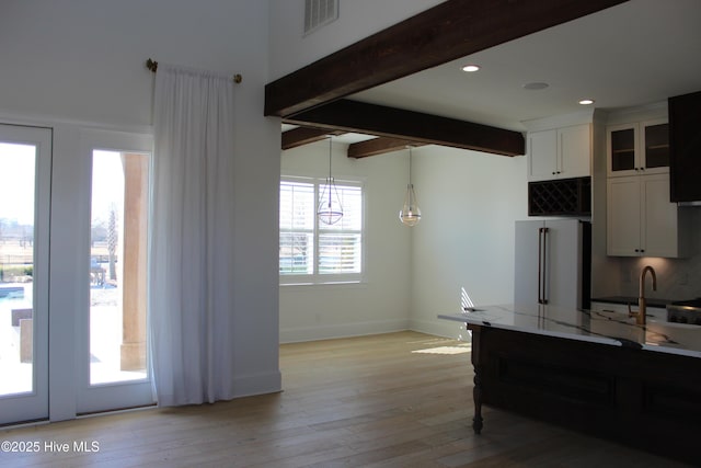 kitchen with high end fridge, hanging light fixtures, beamed ceiling, light hardwood / wood-style floors, and white cabinets