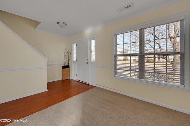 carpeted entryway with ornamental molding