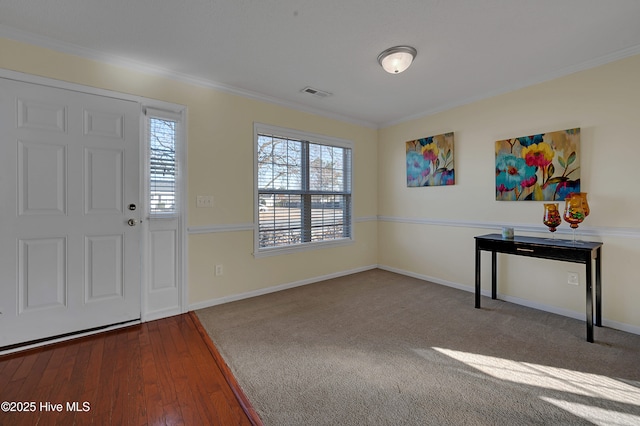 foyer entrance featuring carpet flooring and crown molding