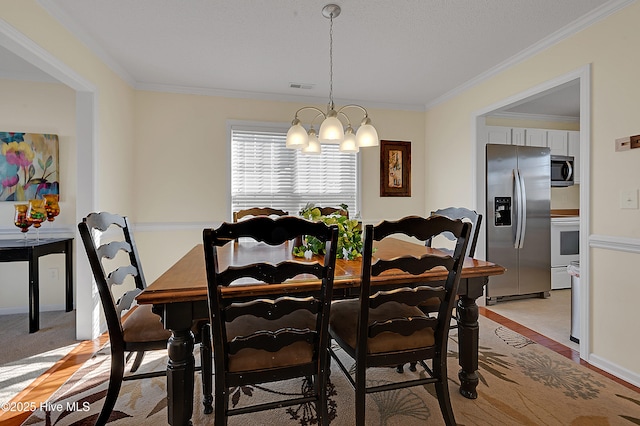 dining space with a notable chandelier and crown molding