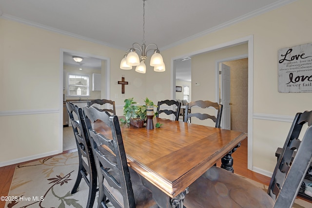 dining area featuring light hardwood / wood-style floors, ornamental molding, and a chandelier