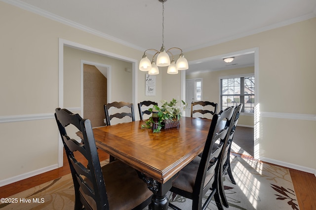 dining area featuring crown molding, hardwood / wood-style flooring, and a notable chandelier