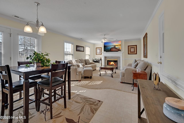 dining space with ceiling fan with notable chandelier, light colored carpet, and ornamental molding