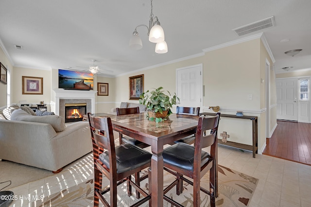 dining room with ceiling fan with notable chandelier and crown molding