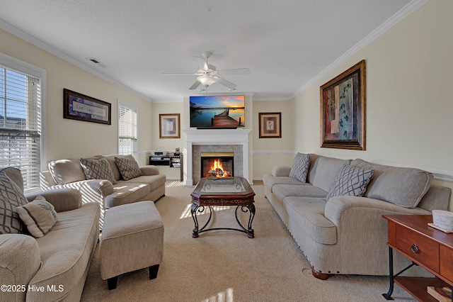 carpeted living room featuring ceiling fan, a fireplace, and ornamental molding