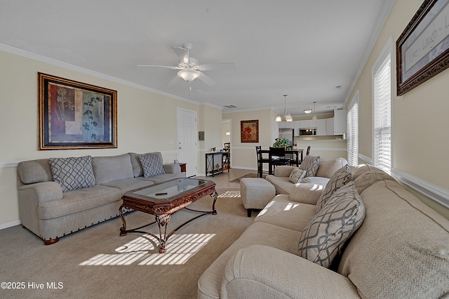 living room featuring ceiling fan, crown molding, and light carpet