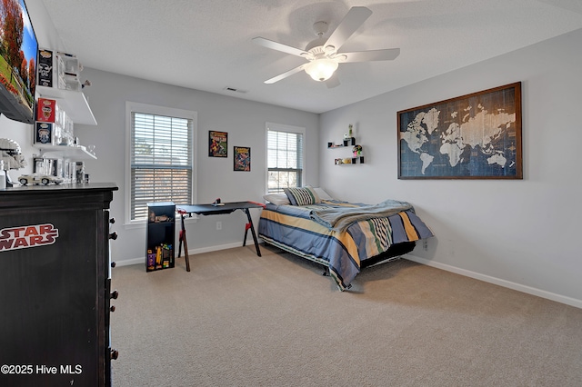 bedroom featuring ceiling fan, light colored carpet, and a textured ceiling