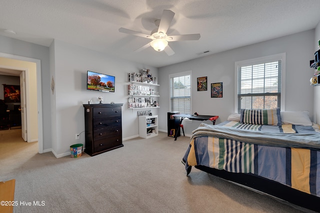 carpeted bedroom featuring ceiling fan and a textured ceiling