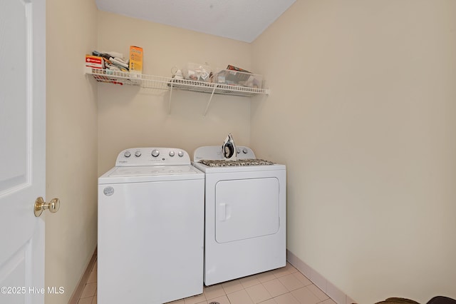 laundry area with washing machine and dryer and light tile patterned flooring