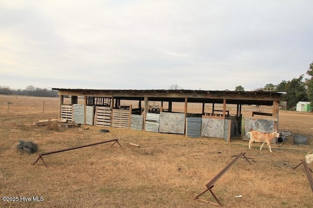 view of horse barn with a rural view