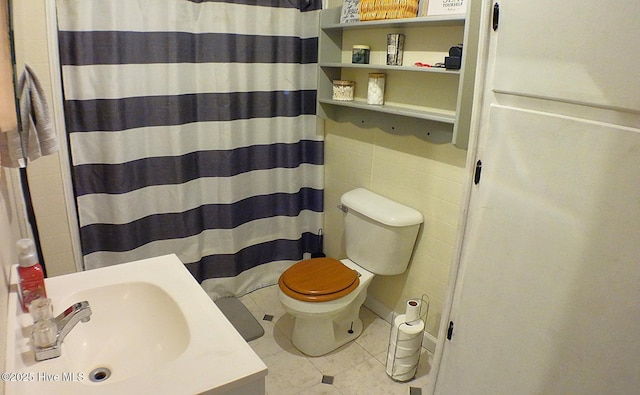 bathroom with curtained shower, sink, and toilet