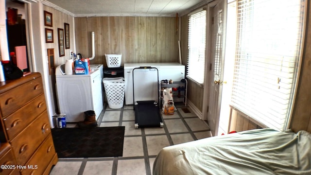 bedroom featuring washer and dryer, light tile patterned flooring, crown molding, and wooden walls