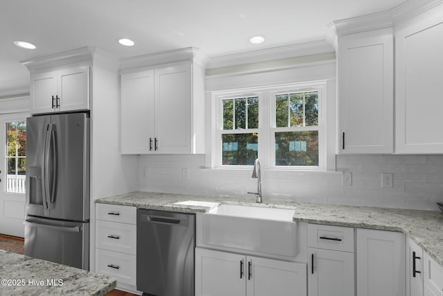 kitchen with light stone countertops, sink, white cabinets, and appliances with stainless steel finishes