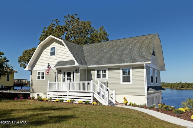 view of front of house with covered porch, a water view, a garage, and a front yard