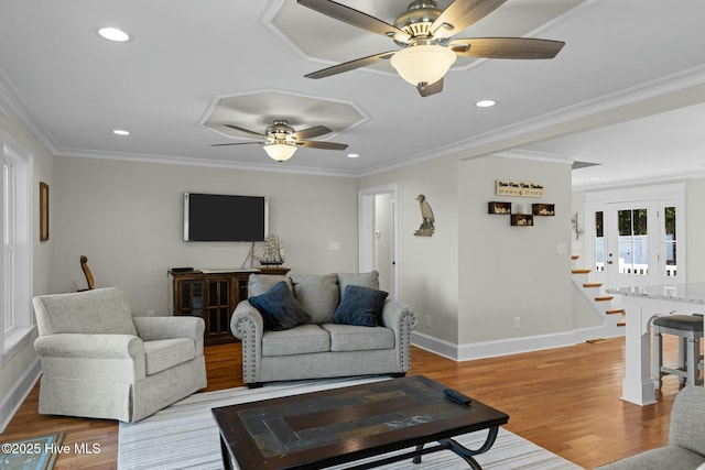 living room featuring ceiling fan, light wood-type flooring, and ornamental molding