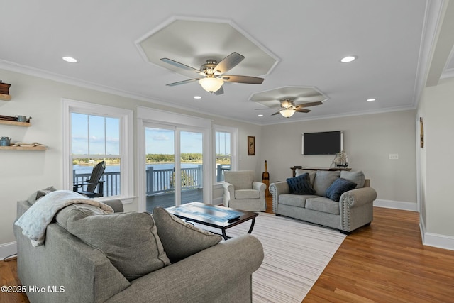 living room with light hardwood / wood-style floors, ceiling fan, and ornamental molding