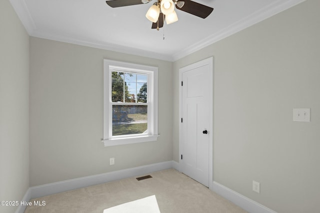 carpeted empty room with ceiling fan and crown molding