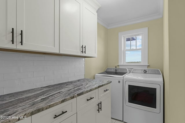 laundry room featuring separate washer and dryer, crown molding, and cabinets