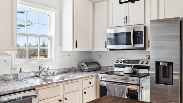 kitchen with white cabinets, a healthy amount of sunlight, appliances with stainless steel finishes, and sink