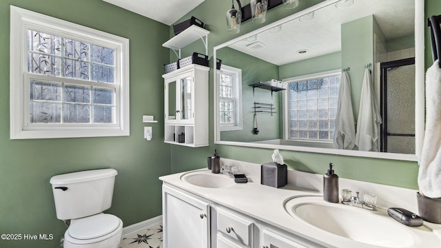 bathroom featuring a shower with door, a wealth of natural light, toilet, and vanity