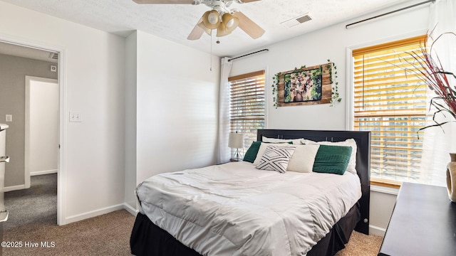 bedroom featuring ceiling fan, light colored carpet, and a textured ceiling