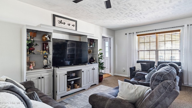 carpeted living room with ceiling fan and a textured ceiling