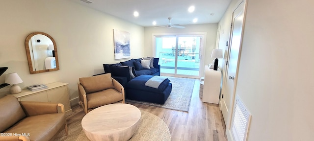 living room with ceiling fan and light hardwood / wood-style floors