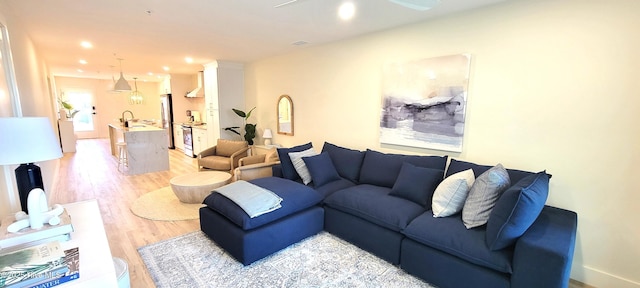 living room with light hardwood / wood-style flooring and sink