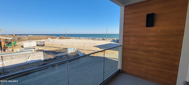 balcony featuring a water view and a beach view