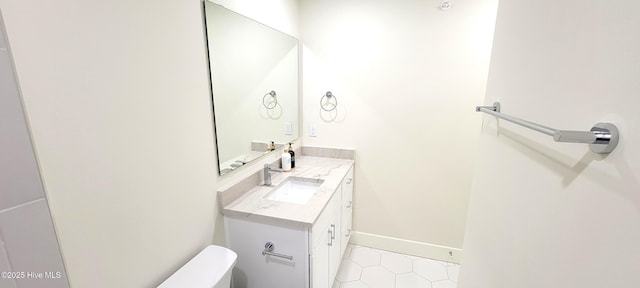 bathroom featuring tile patterned flooring, vanity, and toilet