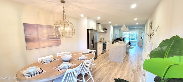 dining area featuring light hardwood / wood-style floors and a notable chandelier