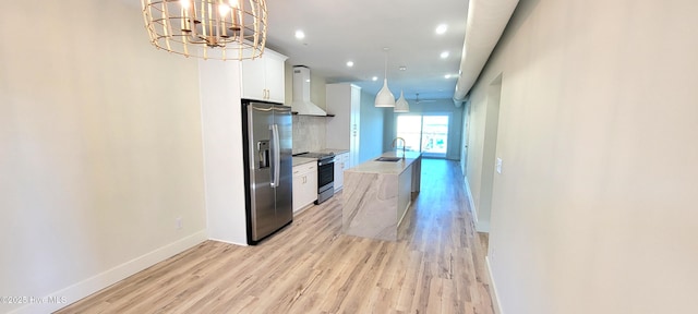 kitchen featuring white cabinetry, sink, wall chimney exhaust hood, hanging light fixtures, and appliances with stainless steel finishes