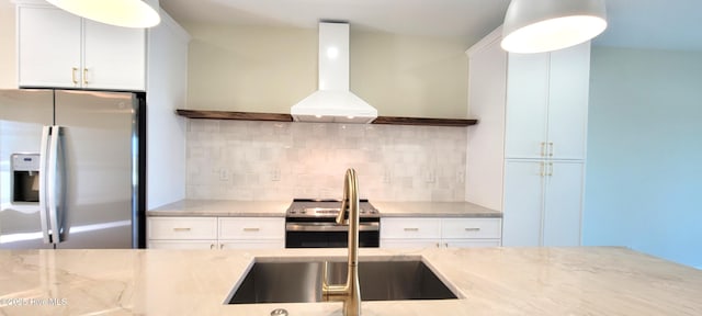 kitchen with backsplash, white cabinets, range hood, light stone counters, and stainless steel appliances