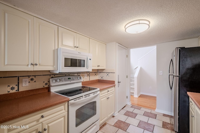 kitchen featuring decorative backsplash, white appliances, and a textured ceiling