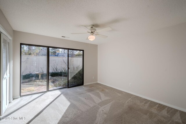 carpeted empty room with ceiling fan and a textured ceiling