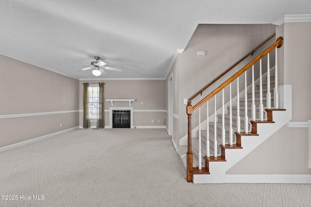 unfurnished living room with a textured ceiling, carpet floors, ceiling fan, and crown molding