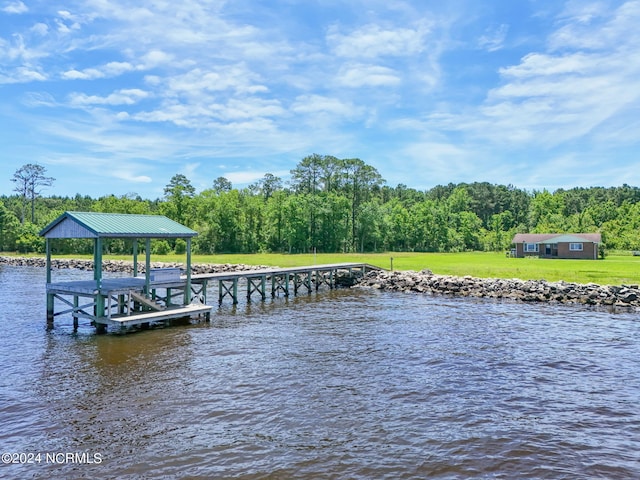 view of dock with a water view and a lawn