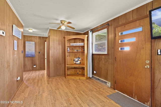 foyer featuring wood walls, ceiling fan, light hardwood / wood-style floors, and ornamental molding