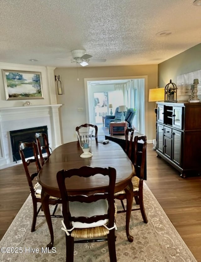 dining space featuring dark wood-type flooring and a textured ceiling