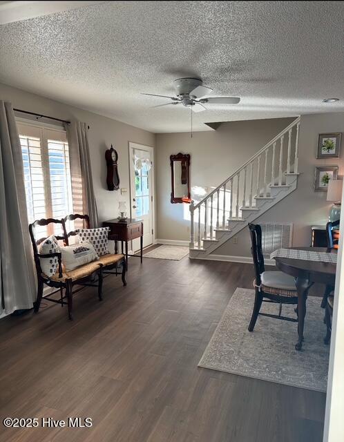 interior space featuring ceiling fan, a textured ceiling, dark hardwood / wood-style floors, and a healthy amount of sunlight