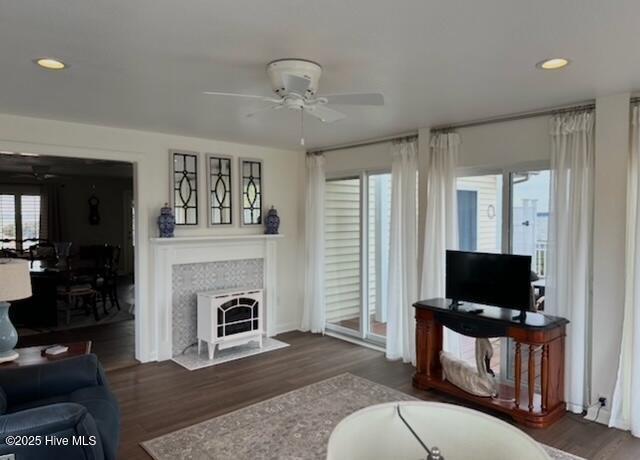 living room featuring ceiling fan and dark hardwood / wood-style flooring