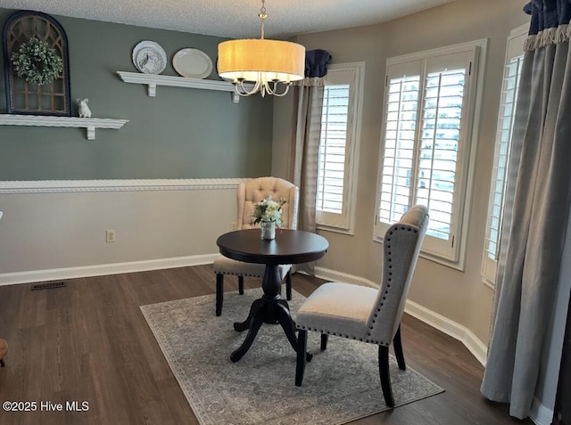 dining area featuring plenty of natural light, dark hardwood / wood-style floors, and a textured ceiling