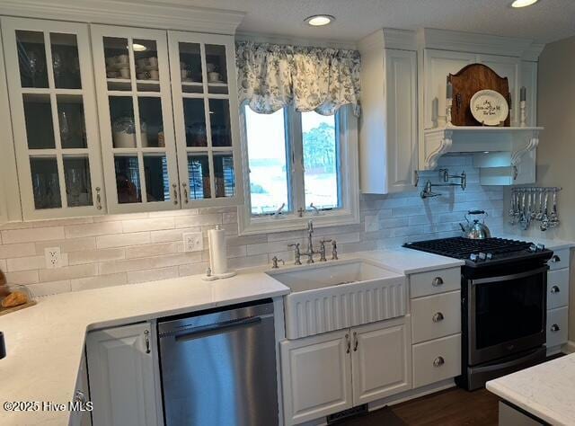 kitchen with sink, dark hardwood / wood-style floors, white cabinets, stainless steel appliances, and backsplash