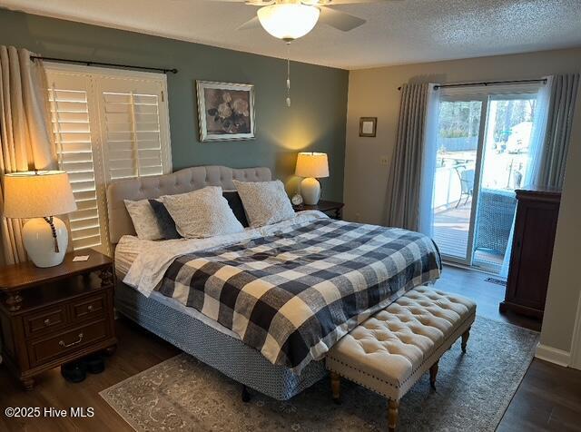 bedroom featuring ceiling fan, dark wood-type flooring, access to exterior, and a textured ceiling