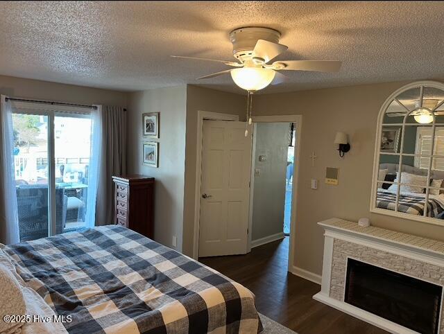 bedroom with dark wood-type flooring, ceiling fan, and a textured ceiling