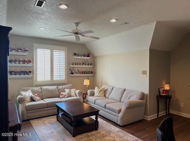 living room with ceiling fan, lofted ceiling, dark hardwood / wood-style flooring, and a textured ceiling