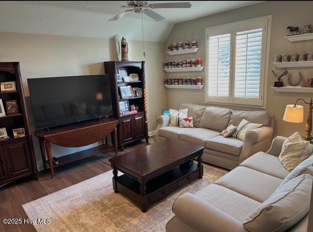 living room with ceiling fan, dark hardwood / wood-style floors, and vaulted ceiling