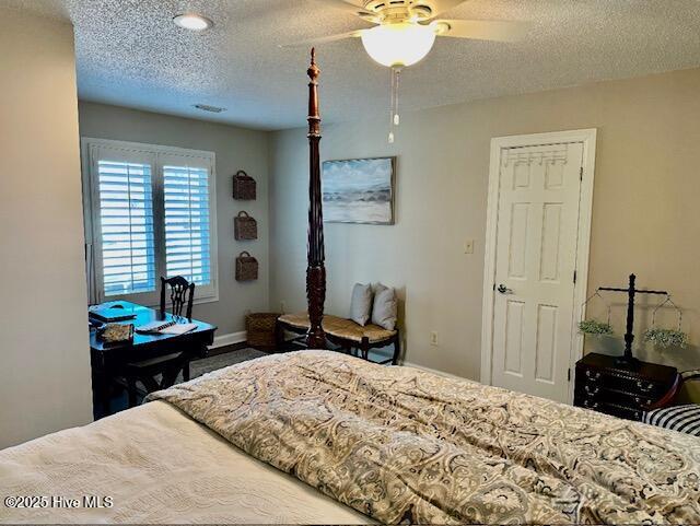 bedroom with ceiling fan and a textured ceiling