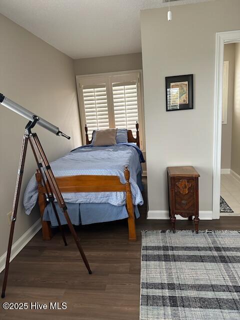 bedroom with dark hardwood / wood-style floors